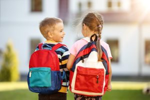 Children with backpacks going to the school. Concept of knowledge and studying.